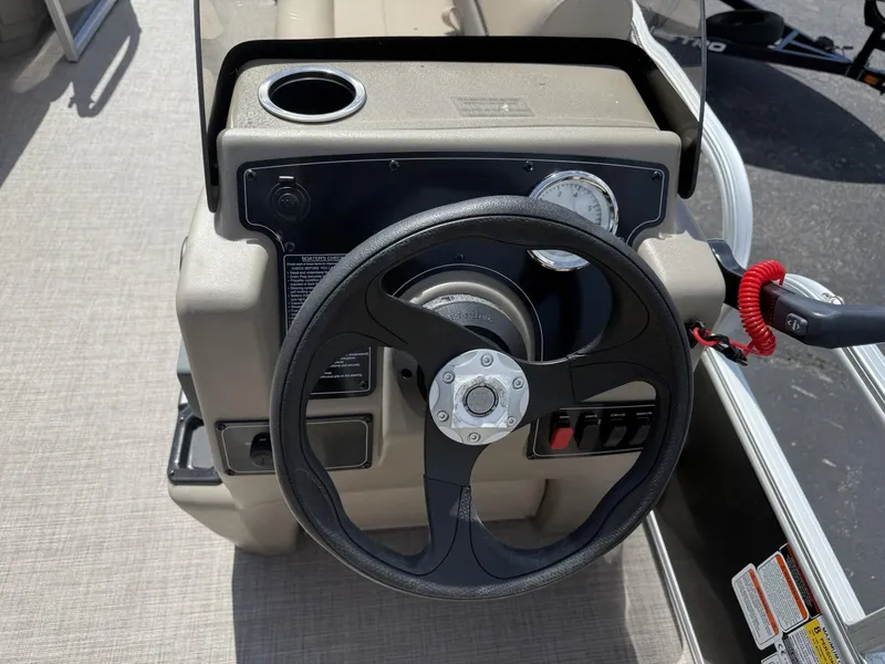 Slide: The Image of Steering console of 2025 Sun Tracker Party Barge 16 DLX with cup holder and controls. - 9
