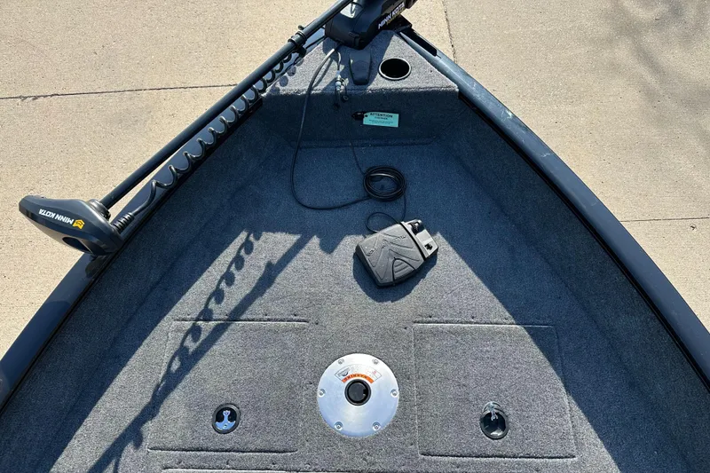 Slide: The Image of 2025 Tracker Pro Guide V-16 SC boat deck with trolling motor and carpeted surface. - 3