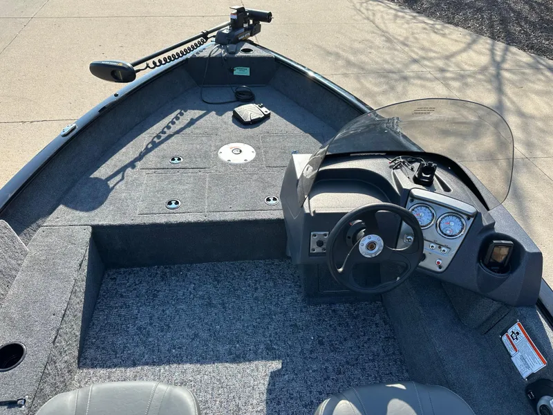 Slide: The Image of 2025 Tracker Pro Guide V-16 SC boat interior with steering console and carpeted deck. - 4