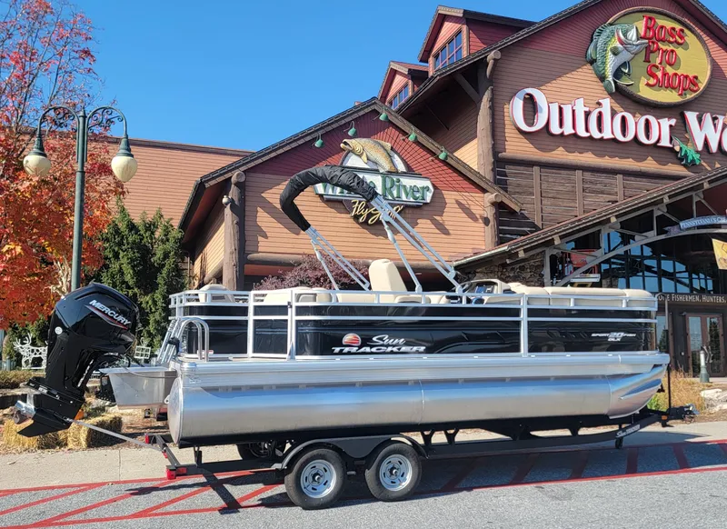 Slide: The Image of 2025 Sun Tracker SportFish 20 DLX pontoon boat outside Bass Pro Shops. - 3