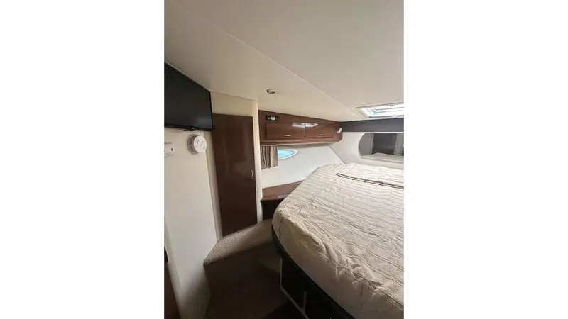 Slide: The Image of 2009 Carver 36 Mariner cabin interior with bed, TV, and wooden cabinetry. - 16