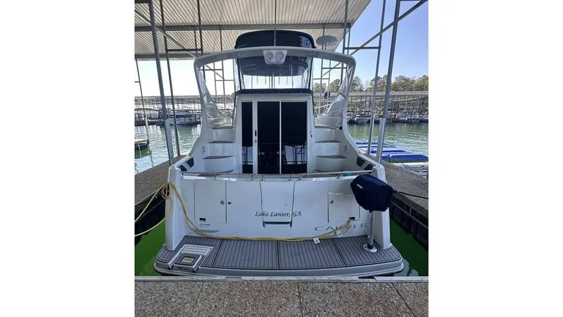 Slide: The Image of 2009 Carver 36 Mariner docked, rear view showing spacious deck and covered marina. - 4