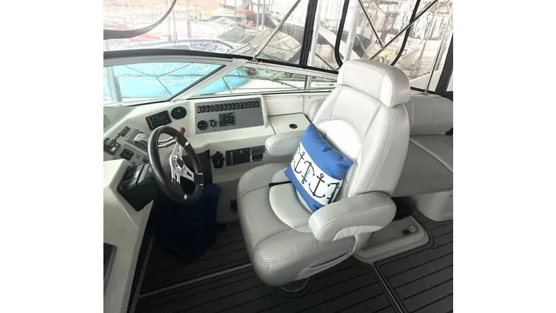 Slide: The Image of 2009 Carver 36 Mariner helm with white captain's chair and nautical-themed pillow. - 6