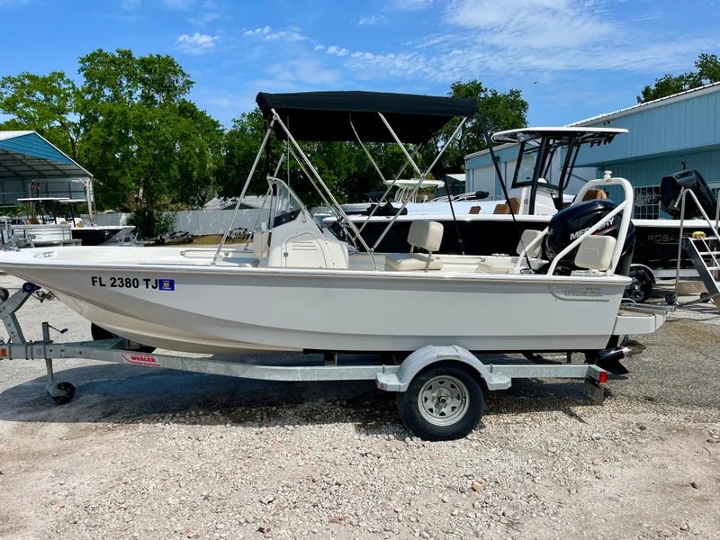 Slide: The Image of 2022 Boston Whaler 17 Montauk boat on trailer, parked outdoors under blue sky. - 5