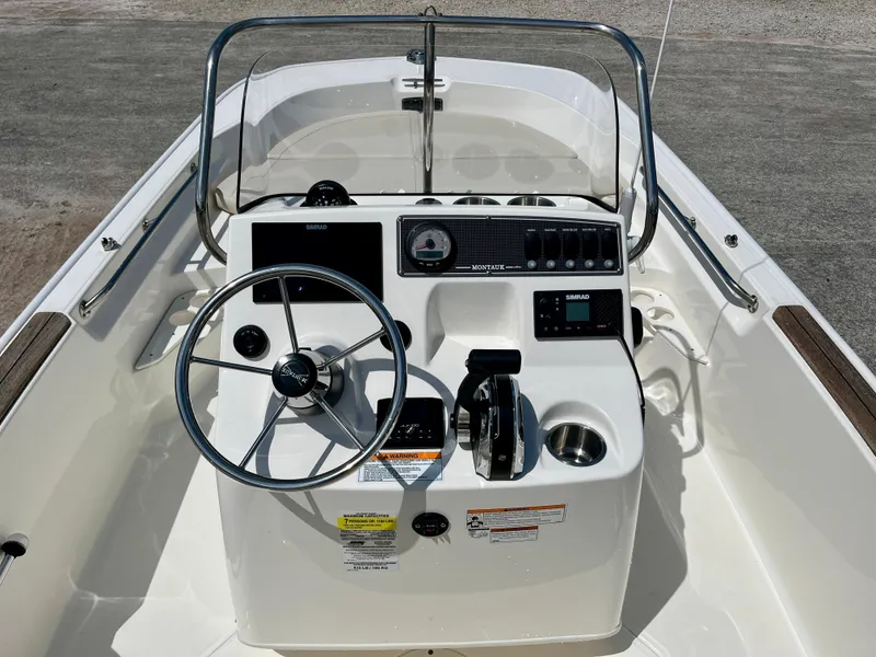 Slide: The Image of 2022 Boston Whaler 17 Montauk boat console with steering wheel and controls. - 9