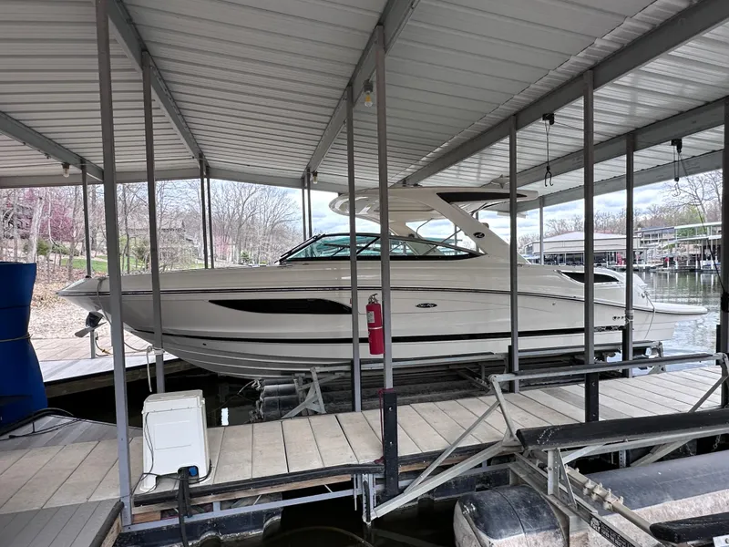 Slide: The Image of 2014 Sea Ray 350 SLX boat docked under a covered marina. - 1