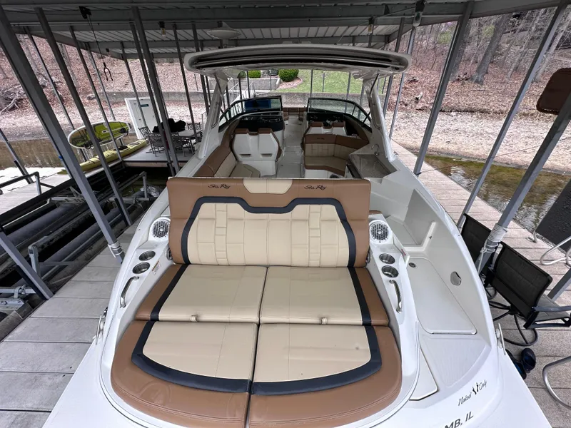 Slide: The Image of 2014 Sea Ray 350 SLX boat with spacious seating and sleek design, docked under a canopy. - 21
