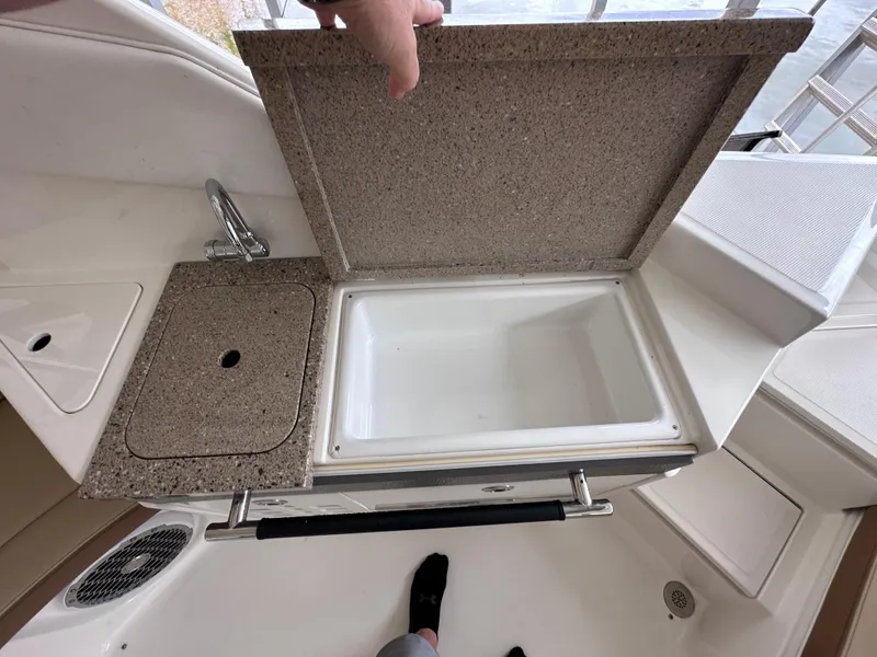 Slide: The Image of 2014 Sea Ray 350 SLX boat interior with open storage compartment and sink. - 23