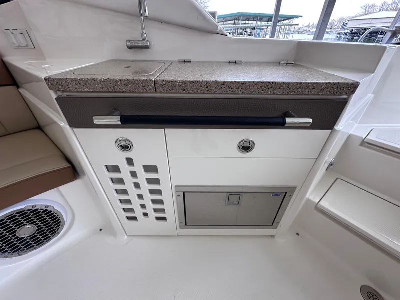 Slide: The Image of 2014 Sea Ray 350 SLX boat interior with kitchenette and storage compartments. - 24