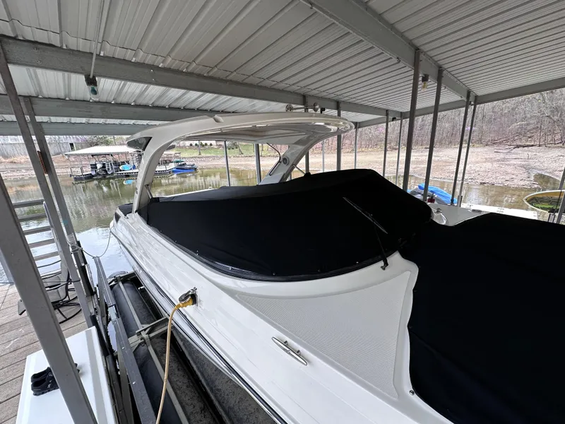 Slide: The Image of 2014 Sea Ray 350 SLX boat docked under a covered marina. - 32