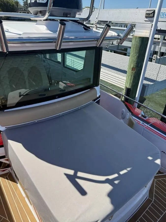 Slide: The Image of 2021 Axopar 28 CABIN boat docked, featuring a covered deck and sleek design. - 12