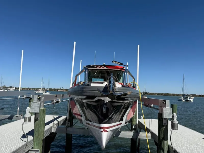 Slide: The Image of 2021 Axopar 28 CABIN boat docked on a sunny day, surrounded by calm waters. - 13