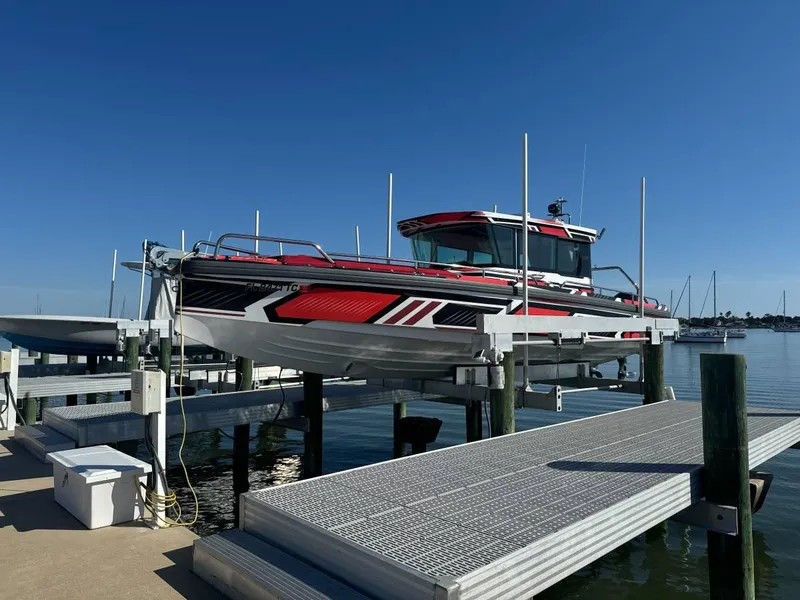Slide: The Image of 2021 Axopar 28 CABIN boat docked on a lift under clear blue sky. - 3