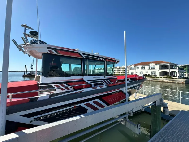 Slide: The Image of 2021 Axopar 28 CABIN boat docked at marina with modern buildings in background. - 5