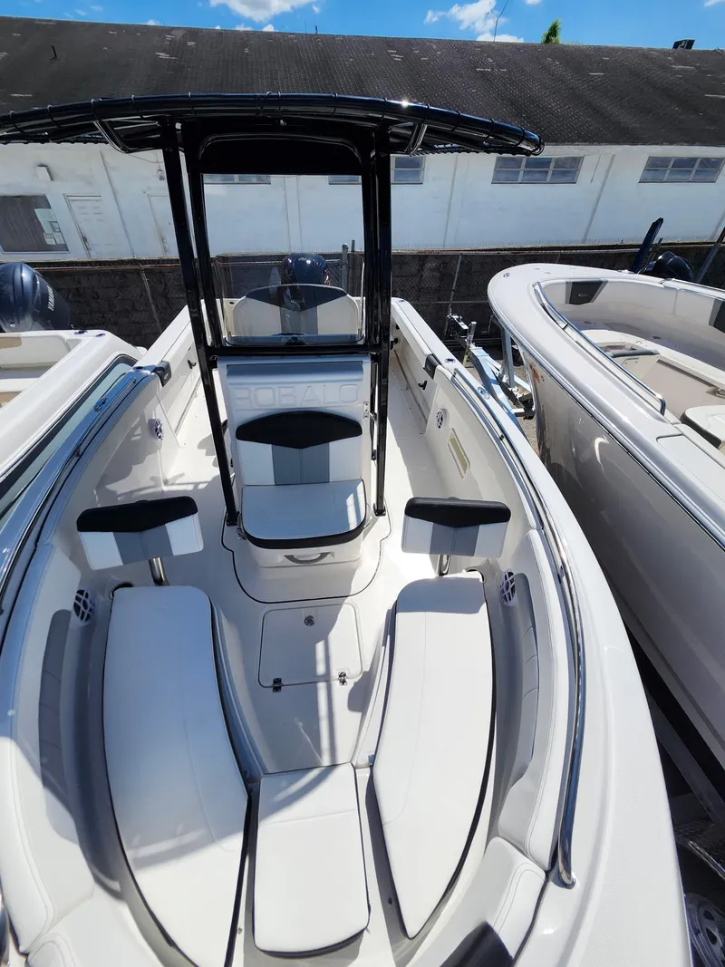 Slide: The Image of 2025 Robalo 222 Explorer boat interior with seating and console, docked outdoors. - 4
