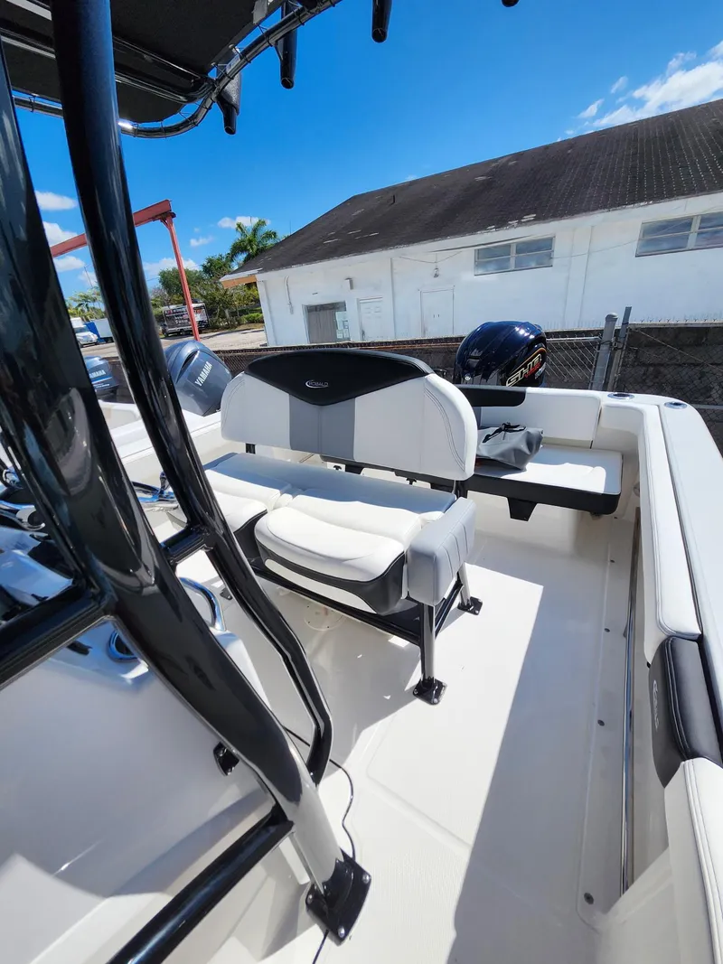 Slide: The Image of 2025 Robalo 222 Explorer boat interior with seating and console, under clear blue sky. - 7