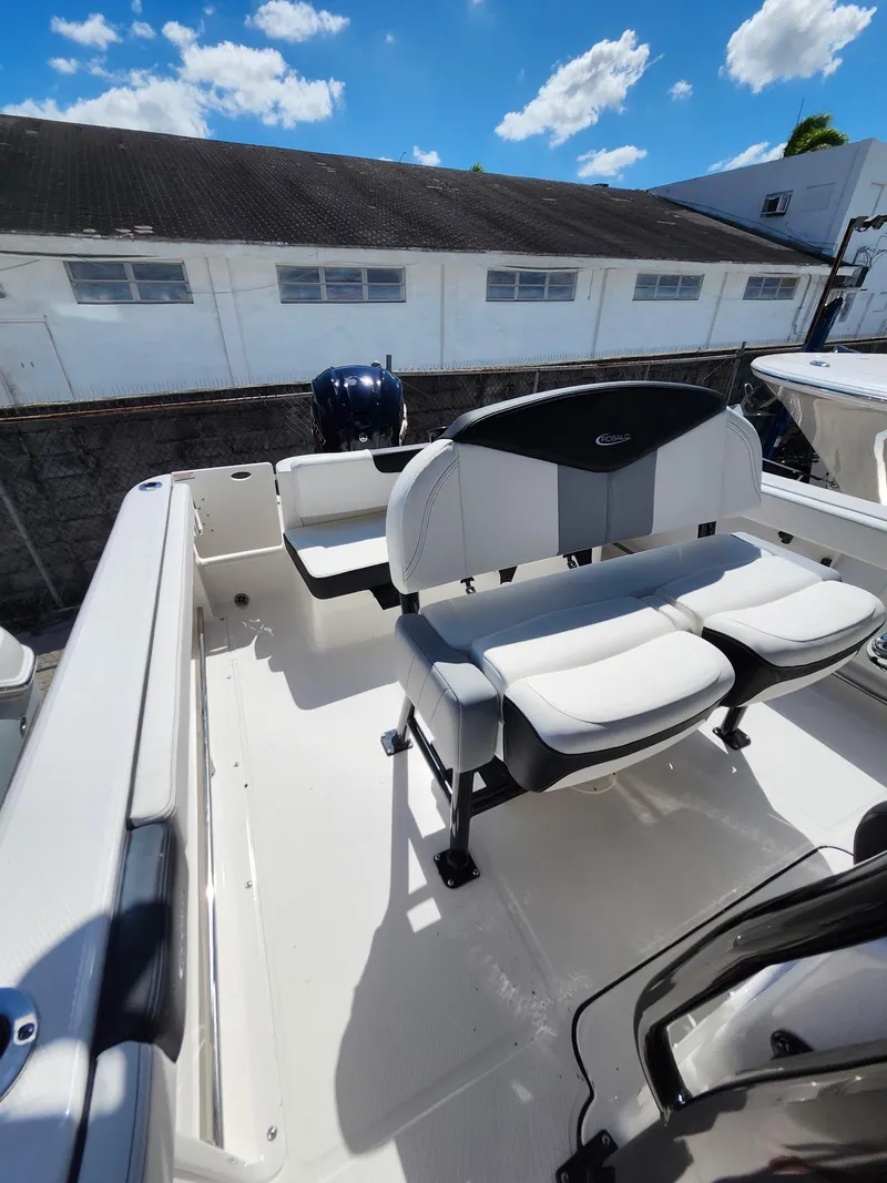 Slide: The Image of 2025 Robalo 222 Explorer boat interior with seating, under a clear blue sky. - 8