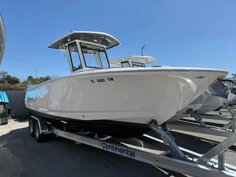 Slide: The Image of 2023 Robalo R250 boat on trailer under clear blue sky. - 11
