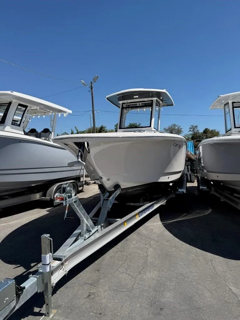 Slide: The Image of 2023 Robalo R250 boat on trailer under clear blue sky. - 3