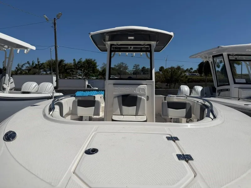 Slide: The Image of 2023 Robalo R250 boat with spacious deck and seating under clear blue sky. - 4