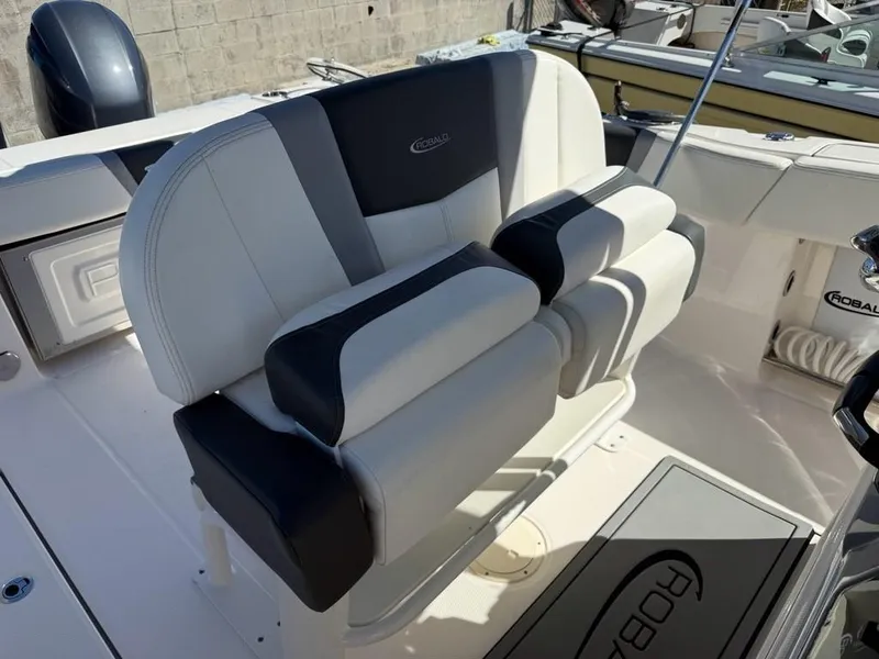 Slide: The Image of 2023 Robalo R250 boat interior with dual-tone seating and logo. - 8
