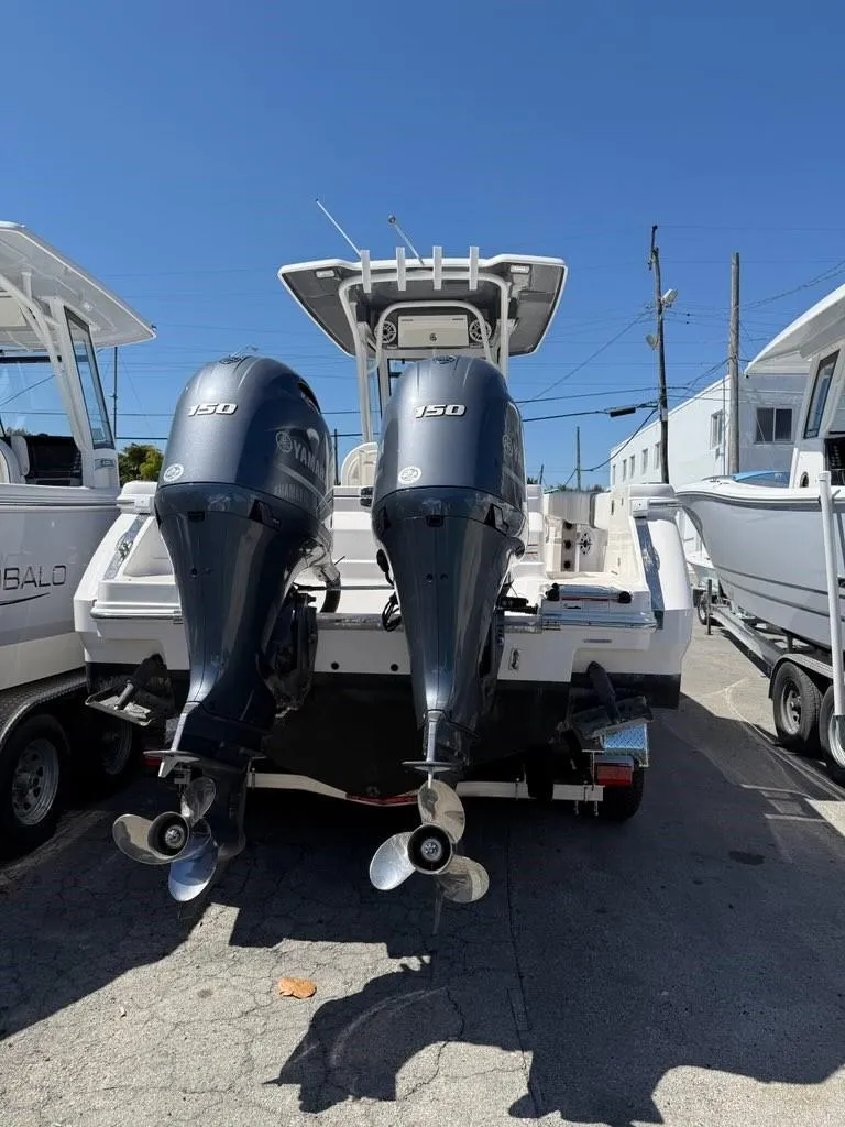 Slide: The Image of 2023 Robalo R250 boat with dual Yamaha 150 engines, parked outdoors. - 9