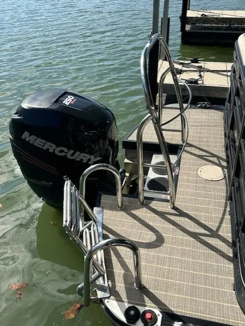 Slide: The Image of 2017 Harris Solstice 250 DC boat with Mercury outboard motor and swim ladder on a sunny day. - 12