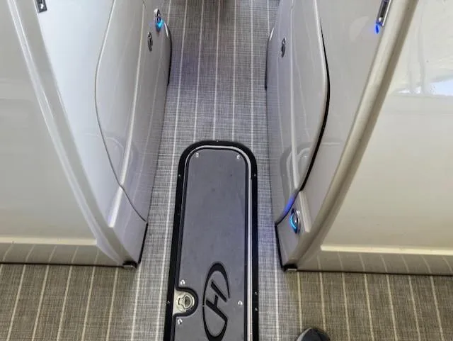 Slide: The Image of Interior view of a 2017 Harris Solstice 250 DC boat, featuring sleek flooring and modern design. - 5