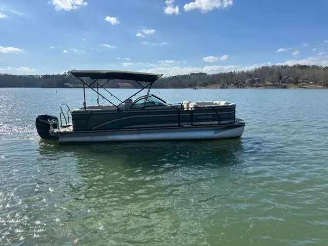 Slide: The Image of 2017 Harris Solstice DC 250 pontoon boat on a calm lake under blue skies. - 0