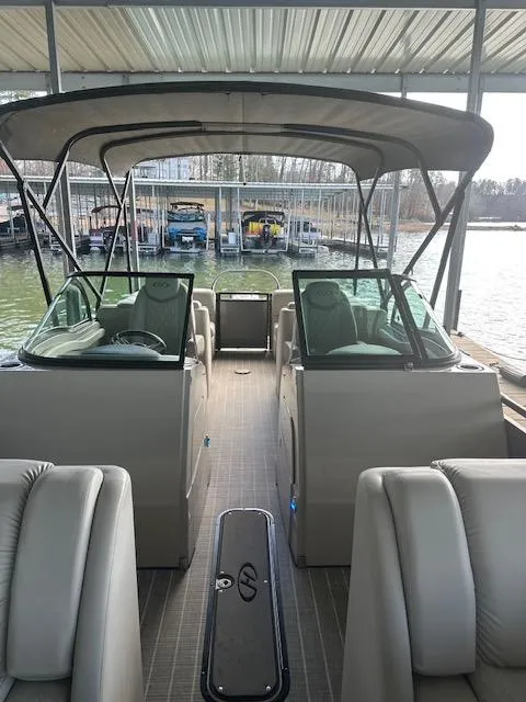 Slide: The Image of 2017 Harris Solstice DC 250 boat interior with seating and canopy, docked at a marina. - 6