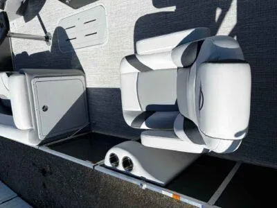 Slide: The Image of 2025 SunCatcher Select 322RC boat interior with gray seating and storage compartments. - 8