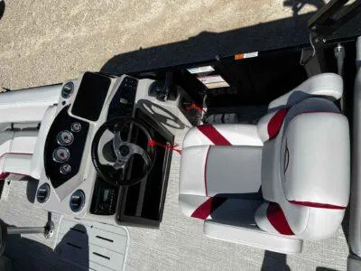 Slide: The Image of 2025 SunCatcher Select 322SS boat interior with steering wheel and cushioned seating. - 7