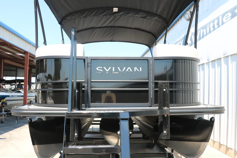 Slide: The Image of 2025 Sylvan Mirage X3 Party Fish pontoon boat, black exterior, docked at marina. - 11