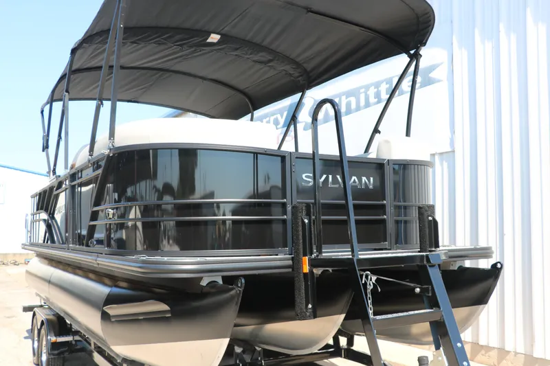 Slide: The Image of 2025 Sylvan Mirage X3 Party Fish pontoon boat with canopy, docked outdoors. - 12