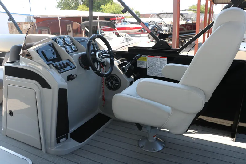 Slide: The Image of 2025 Sylvan Mirage X3 Party Fish boat cockpit with steering wheel and captain's chair. - 33