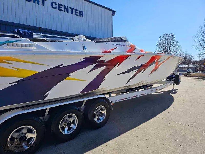 Slide: The Image of 2001 Black Thunder 43 GT Flat Deck boat with vibrant graphics on a trailer. - 12