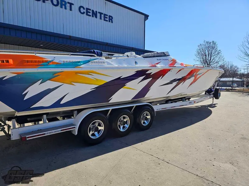 Slide: The Image of 2001 Black Thunder 43 GT Flat Deck boat with vibrant graphics on a trailer. - 13