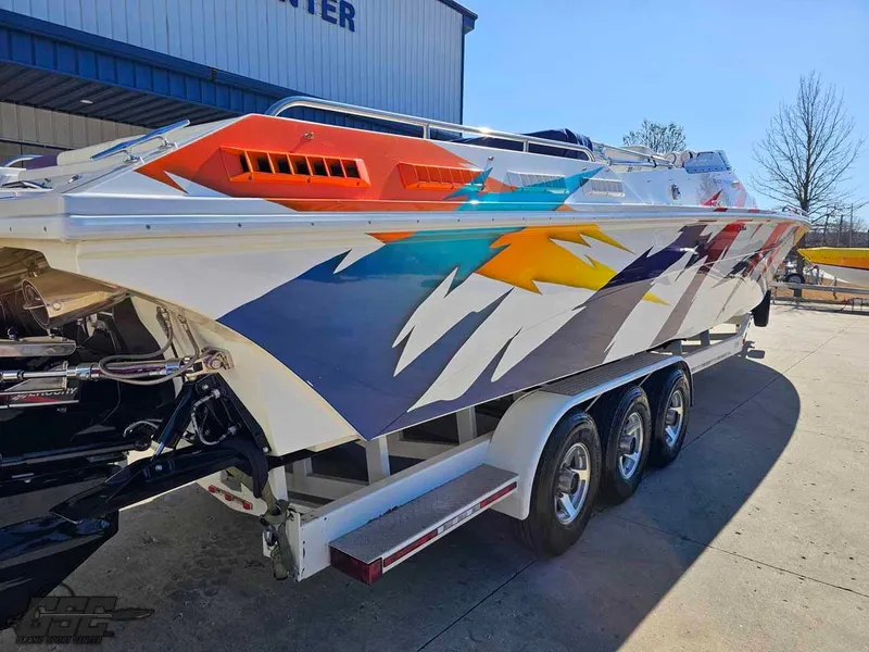 Slide: The Image of 2001 Black Thunder 43 GT Flat Deck boat with vibrant, colorful graphics on a trailer. - 14
