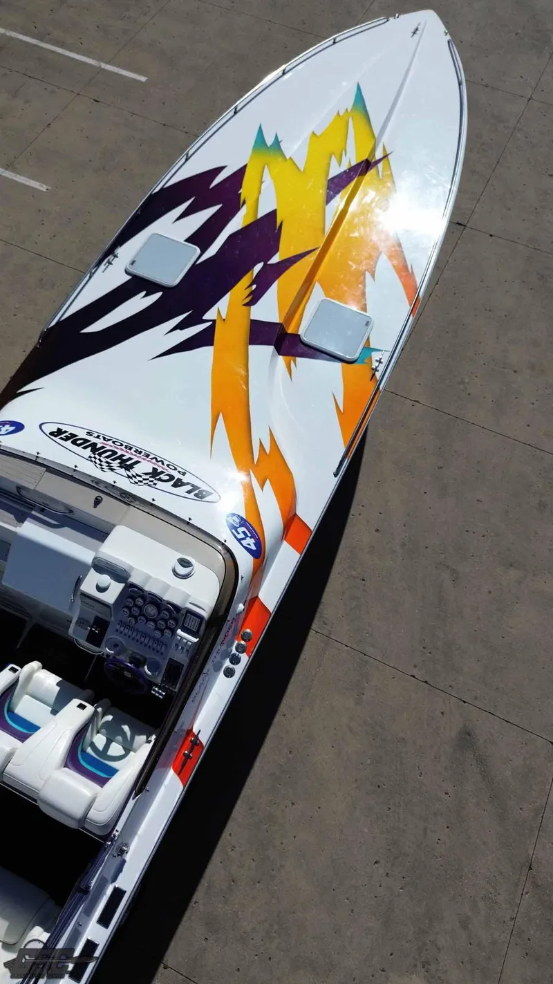 Slide: The Image of 2001 Black Thunder 43 GT Flat Deck boat with vibrant, colorful graphics on deck. - 19