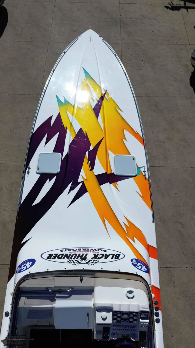 Slide: The Image of 2001 Black Thunder 43 GT Flat Deck boat with vibrant abstract graphics on deck. - 20