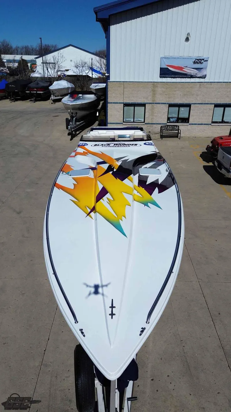 Slide: The Image of 2001 Black Thunder 43 GT Flat Deck boat with vibrant geometric design on deck. - 26