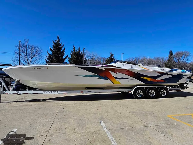 Slide: The Image of 2001 Black Thunder 43 GT Flat Deck boat on trailer, vibrant graphics, clear sky background. - 32
