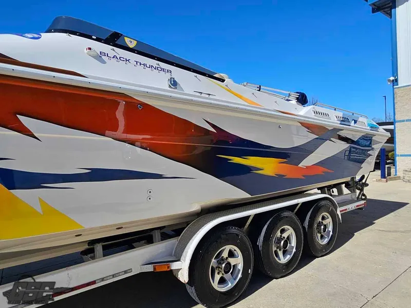 Slide: The Image of 2001 Black Thunder 43 GT Flat Deck boat with vibrant graphics on a trailer. - 36