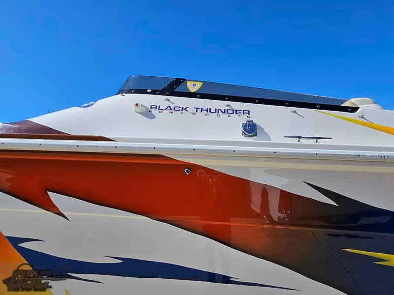 Slide: The Image of 2001 Black Thunder 43 GT Flat Deck boat with vibrant graphics against a clear blue sky. - 37