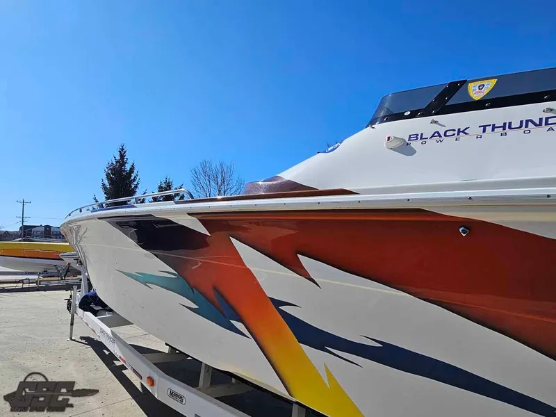 Slide: The Image of 2001 Black Thunder 43 GT Flat Deck powerboat with vibrant graphics on a sunny day. - 38