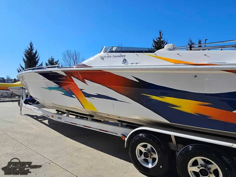 Slide: The Image of 2001 Black Thunder 43 GT Flat Deck boat with vibrant graphics on a trailer. - 39