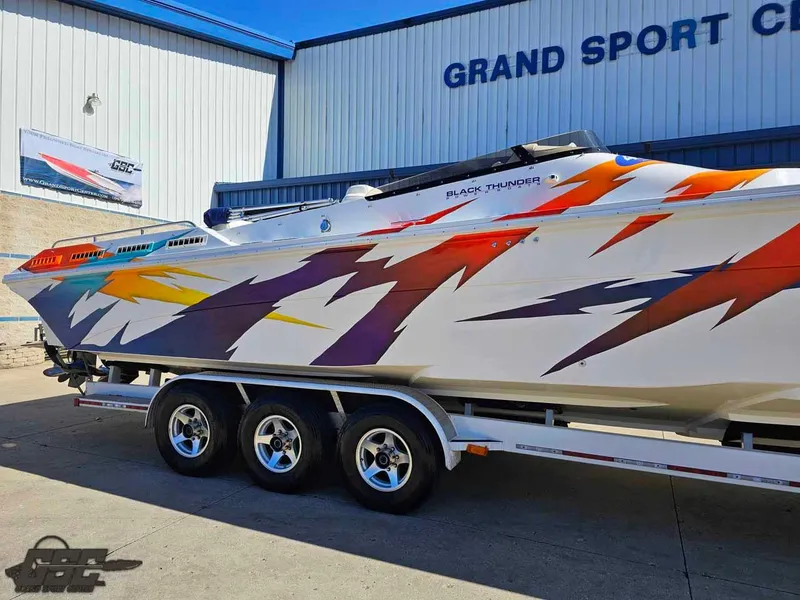 Slide: The Image of 2001 Black Thunder 43 GT Flat Deck boat with vibrant graphics on a trailer. - 4