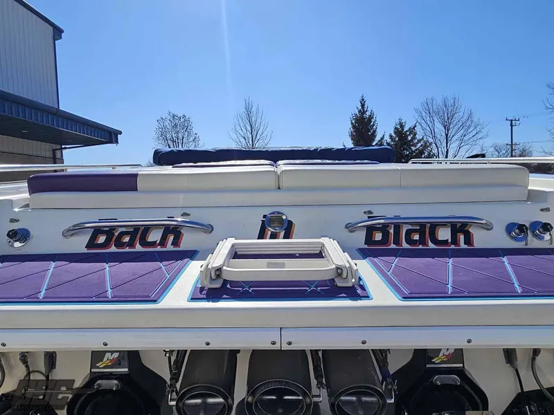 Slide: The Image of 2001 Black Thunder 43 GT Flat Deck boat with purple accents, rear view. - 48