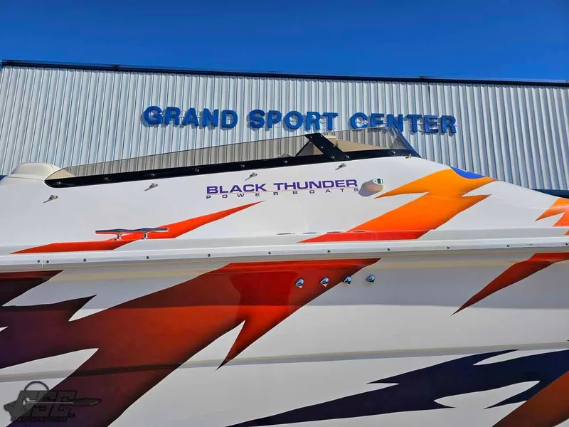 Slide: The Image of 2001 Black Thunder 43 GT Flat Deck boat at Grand Sport Center with vibrant graphics. - 6