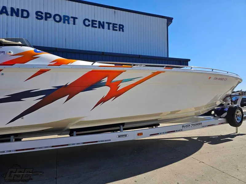 Slide: The Image of 2001 Black Thunder 43 GT Flat Deck boat with vibrant graphics on a trailer. - 8